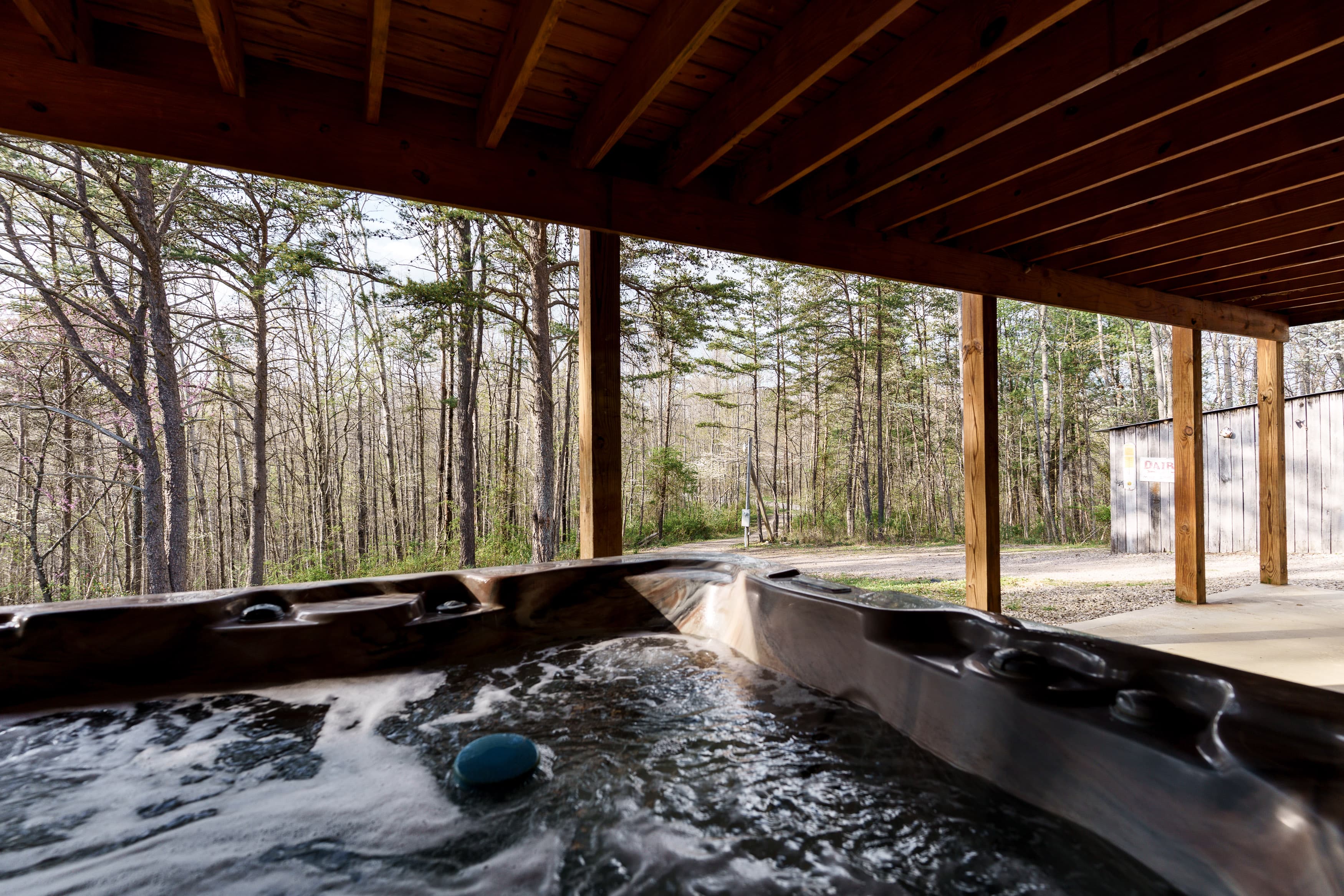Hot tub with bubbling water overlooking a wooded area.