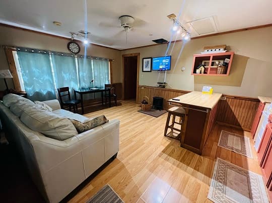 A cozy living area with a sofa, dining table, and television.