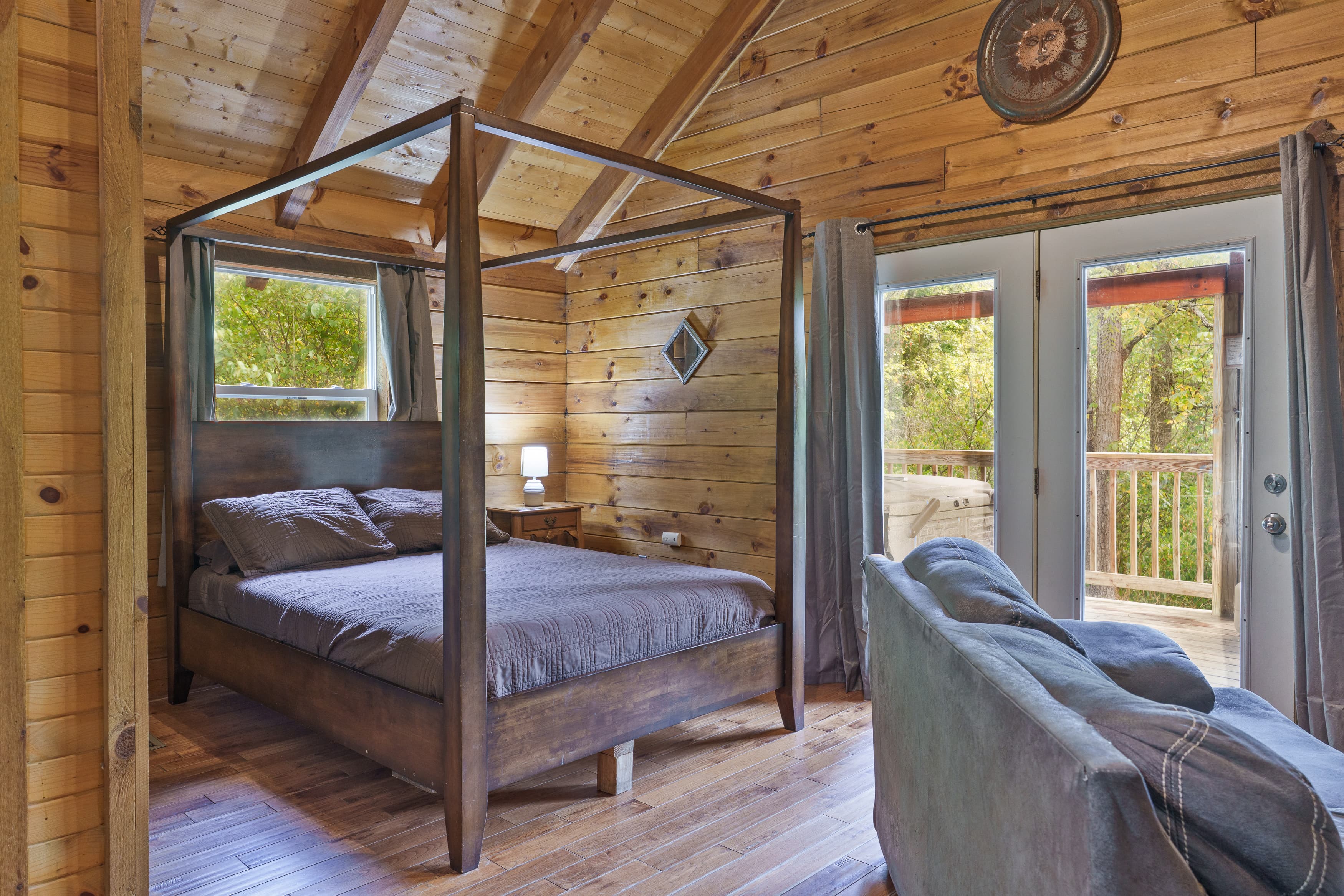 Cozy wooden bedroom featuring a four-poster bed and access to a balcony.