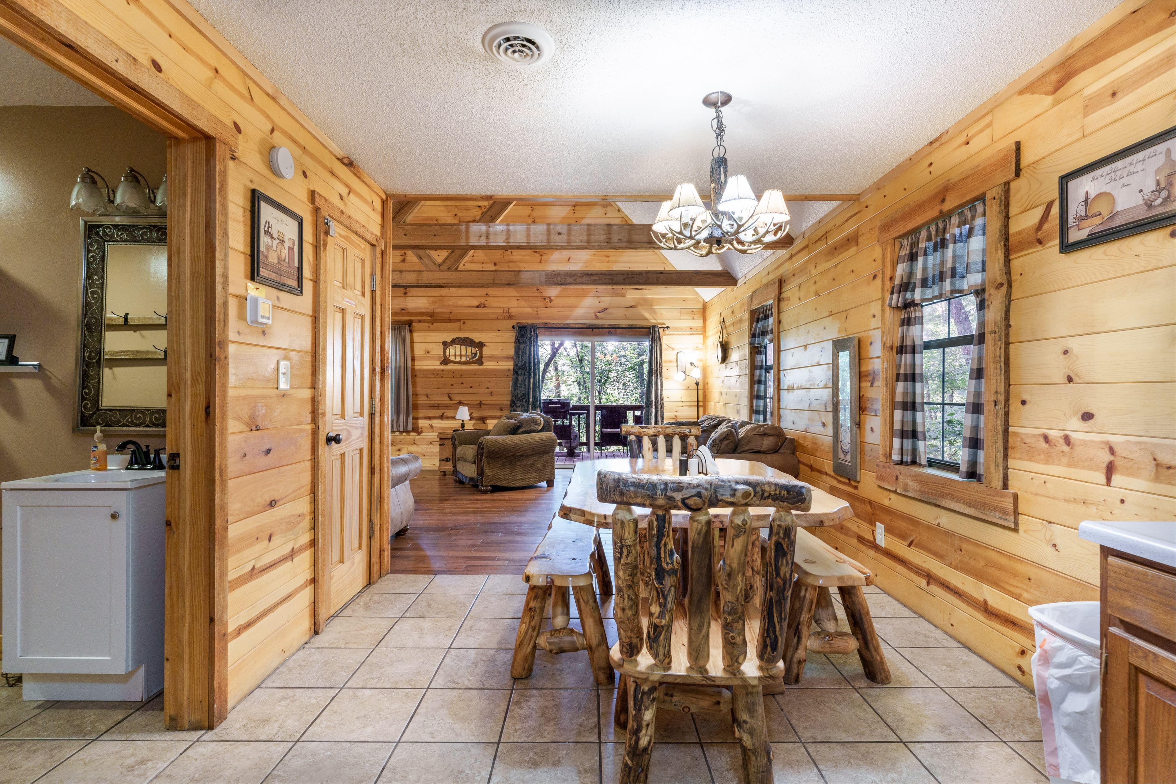 Cozy wooden cabin interior featuring a dining area with log furniture and rustic decor.
