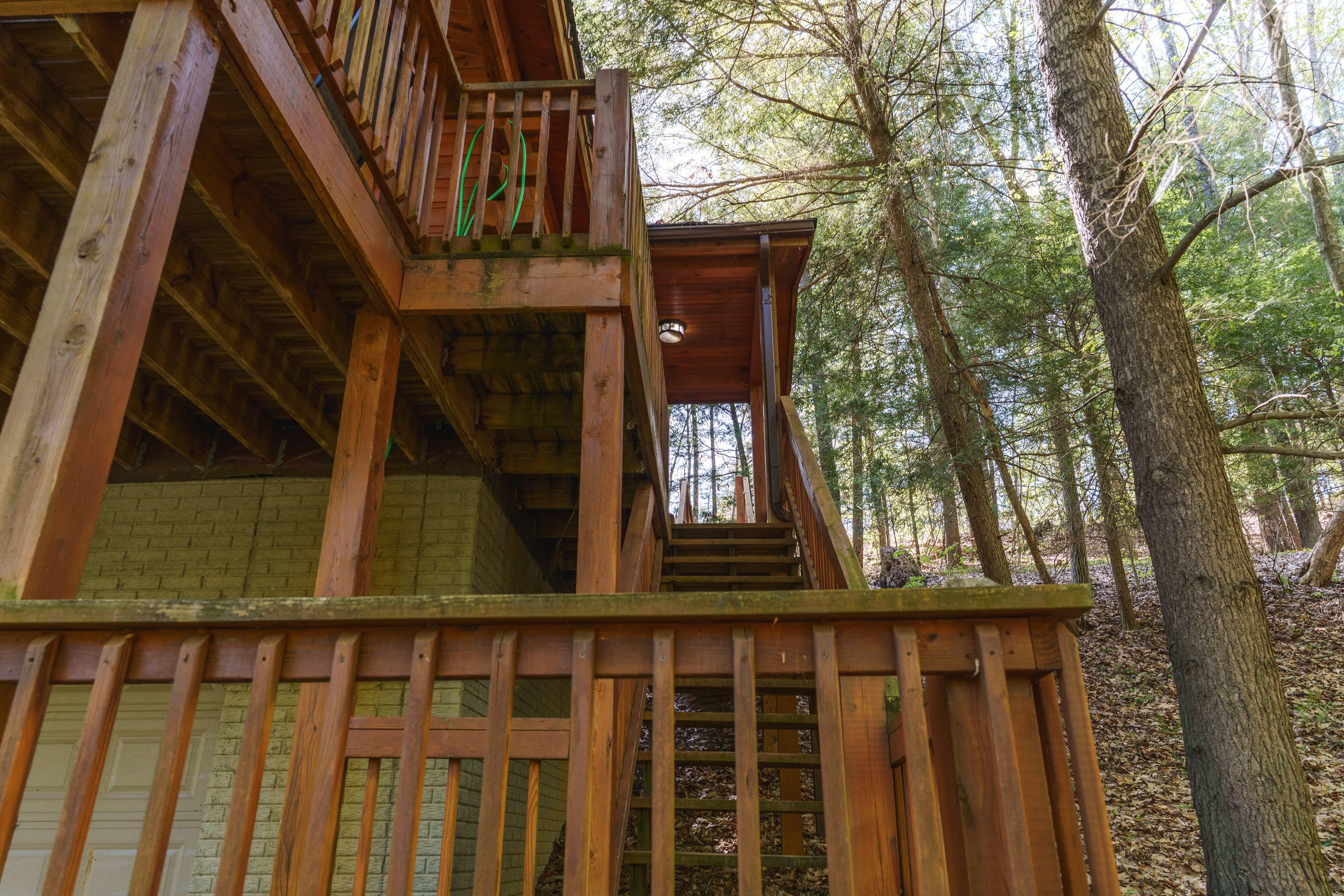 Wooden staircase leading to a cabin, surrounded by trees.
