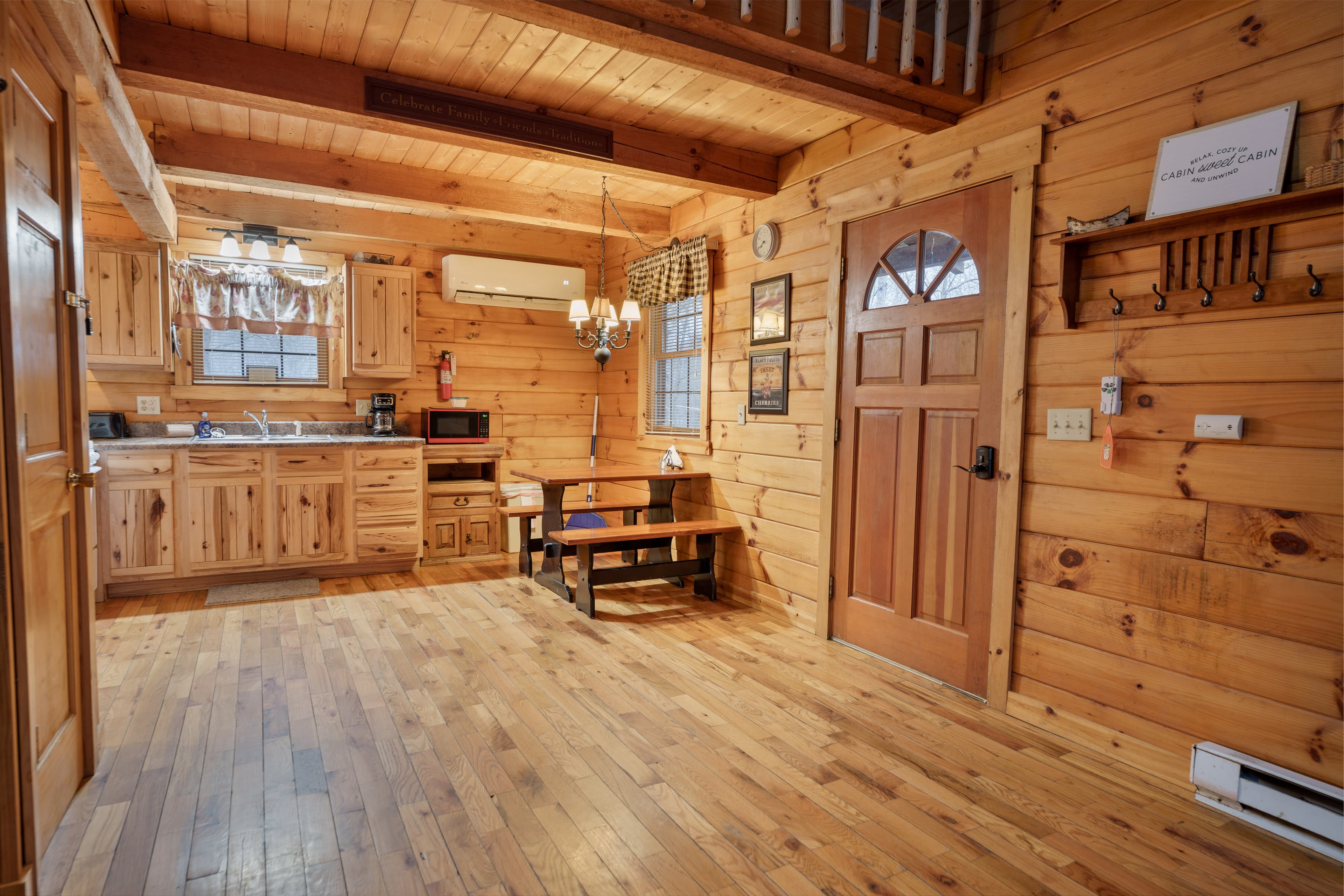 Cozy wooden interior of a rustic cabin with a kitchen area and a small dining table.