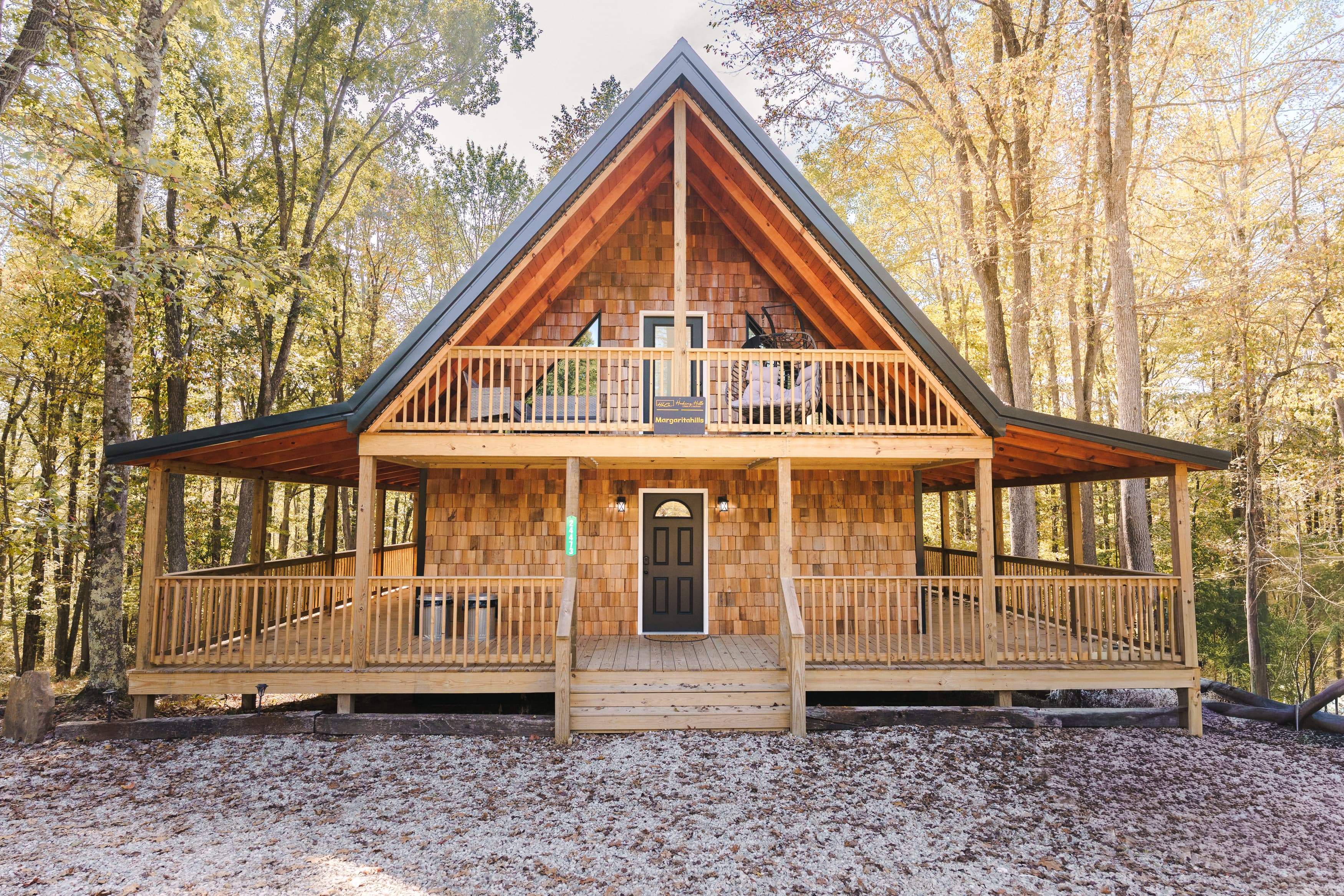 A wooden A-frame cabin surrounded by trees.
