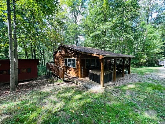 Cozy wooden cabin surrounded by trees and greenery.