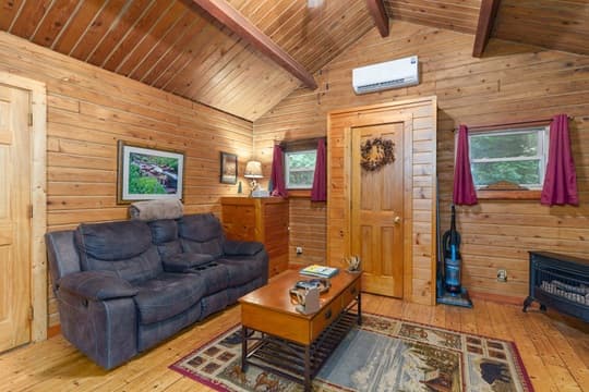 Cozy wooden room featuring a leather sofa, coffee table, and decorative accents.