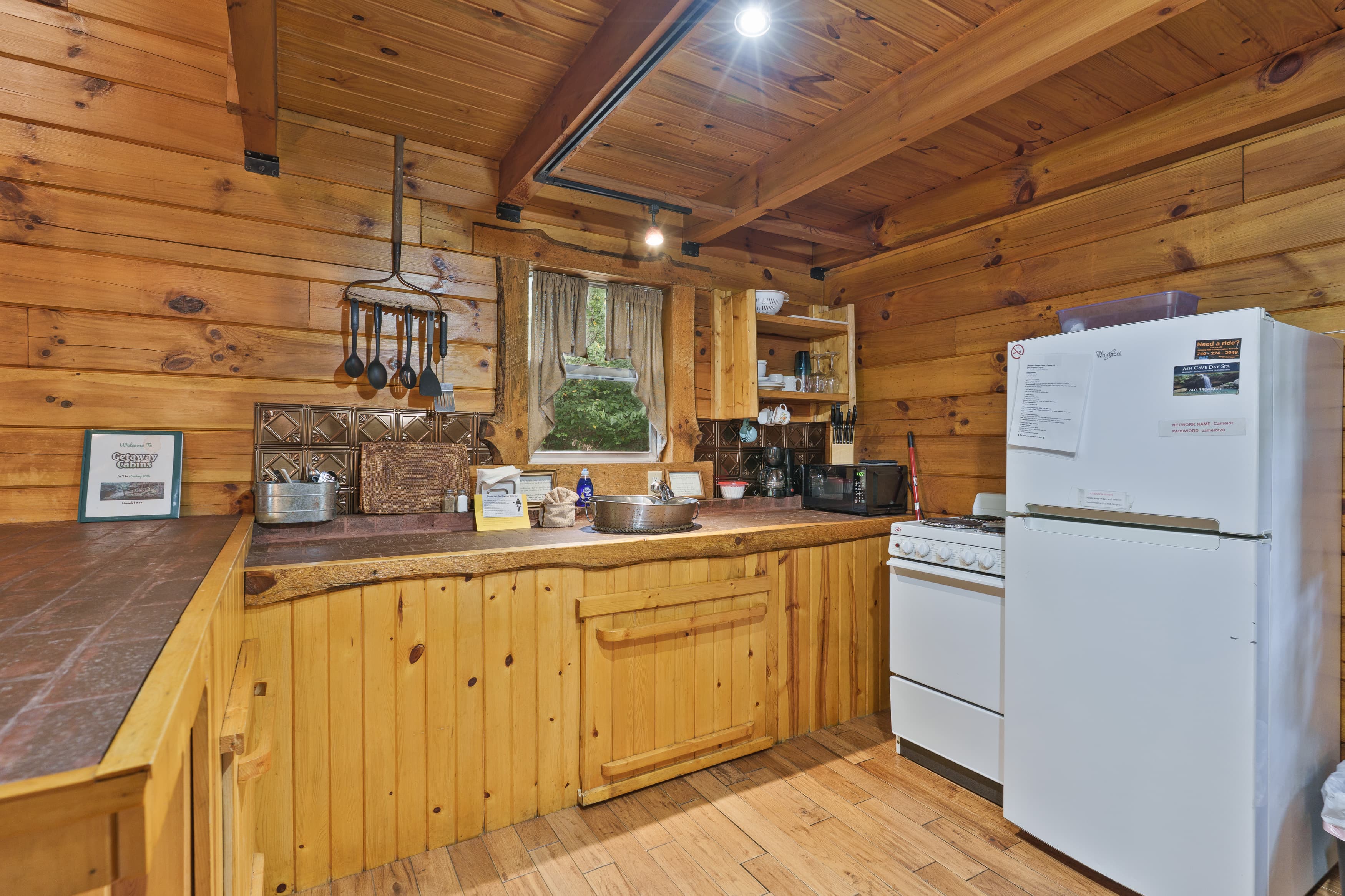 A cozy wooden kitchen featuring a white refrigerator, stove, and various kitchen items.