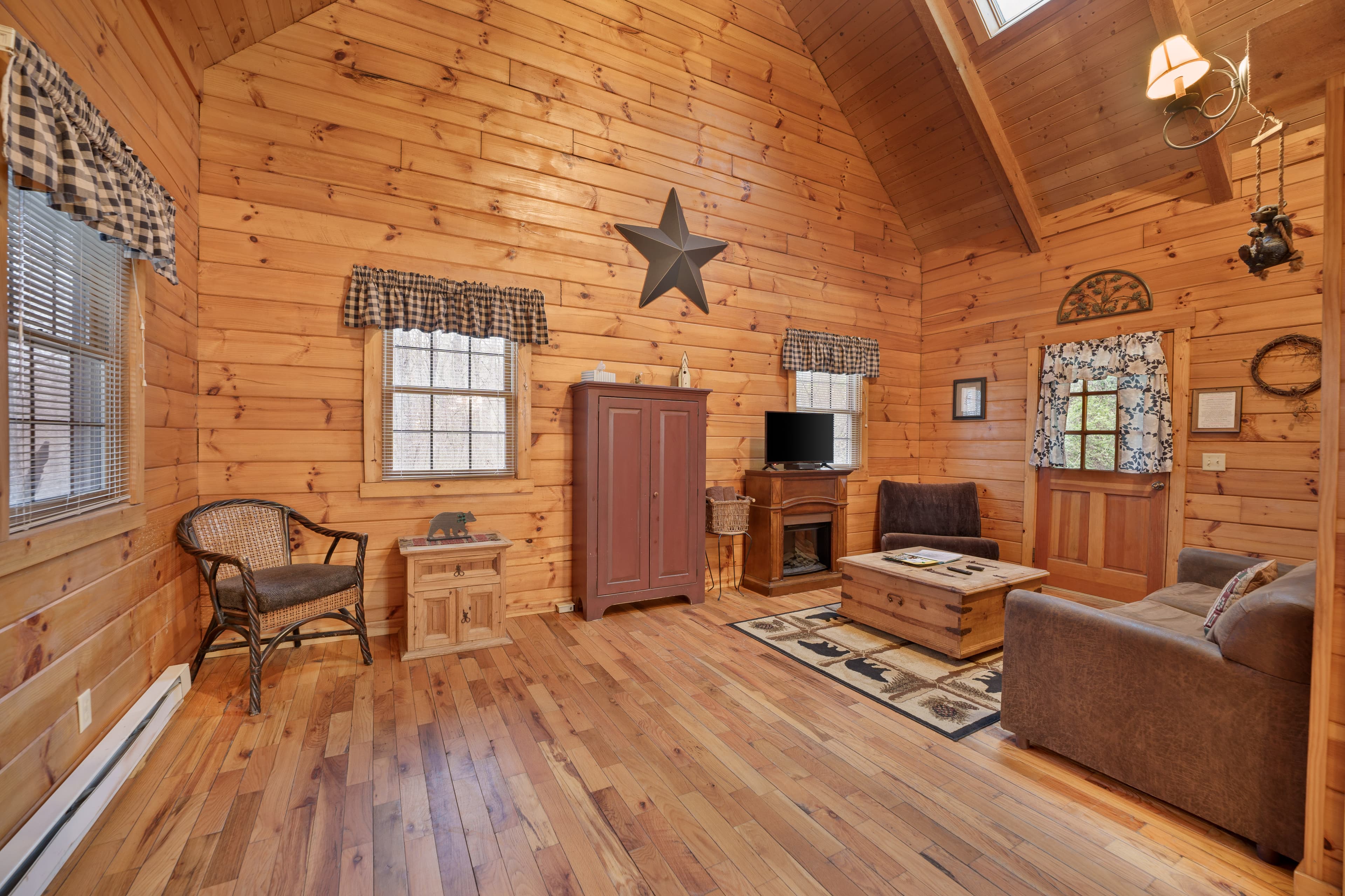 Cozy wooden interior of a cabin featuring a seating area and decorative star on the wall.