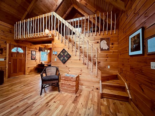 A cozy wooden interior with a staircase, featuring natural wood elements and rustic decor.
