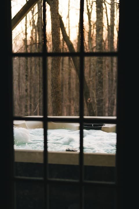 View of a hot tub with bubbles surrounded by trees at sunset.