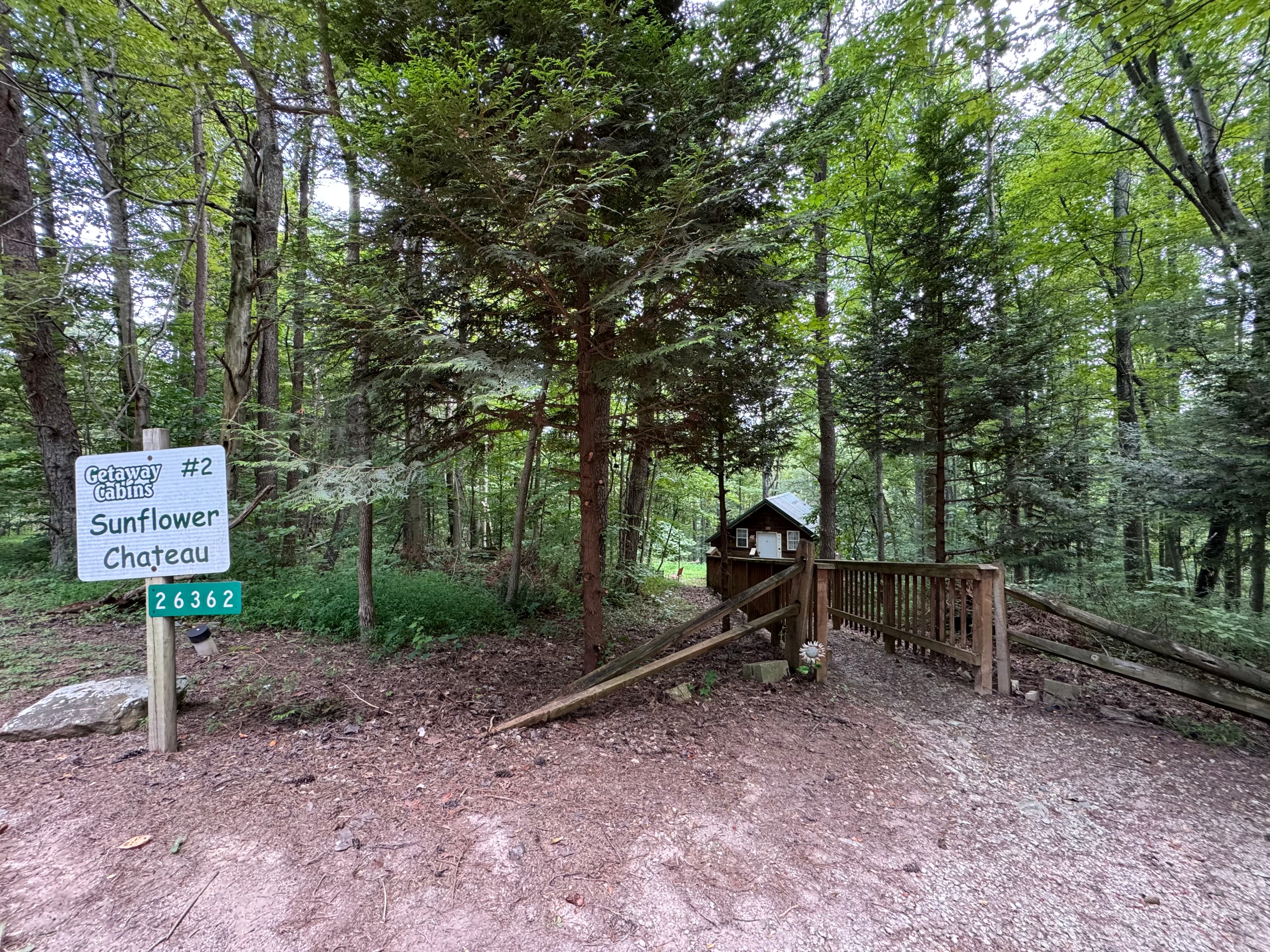 A sign for "Sunflower Chateau" marks the entrance to a wooded cabin area.