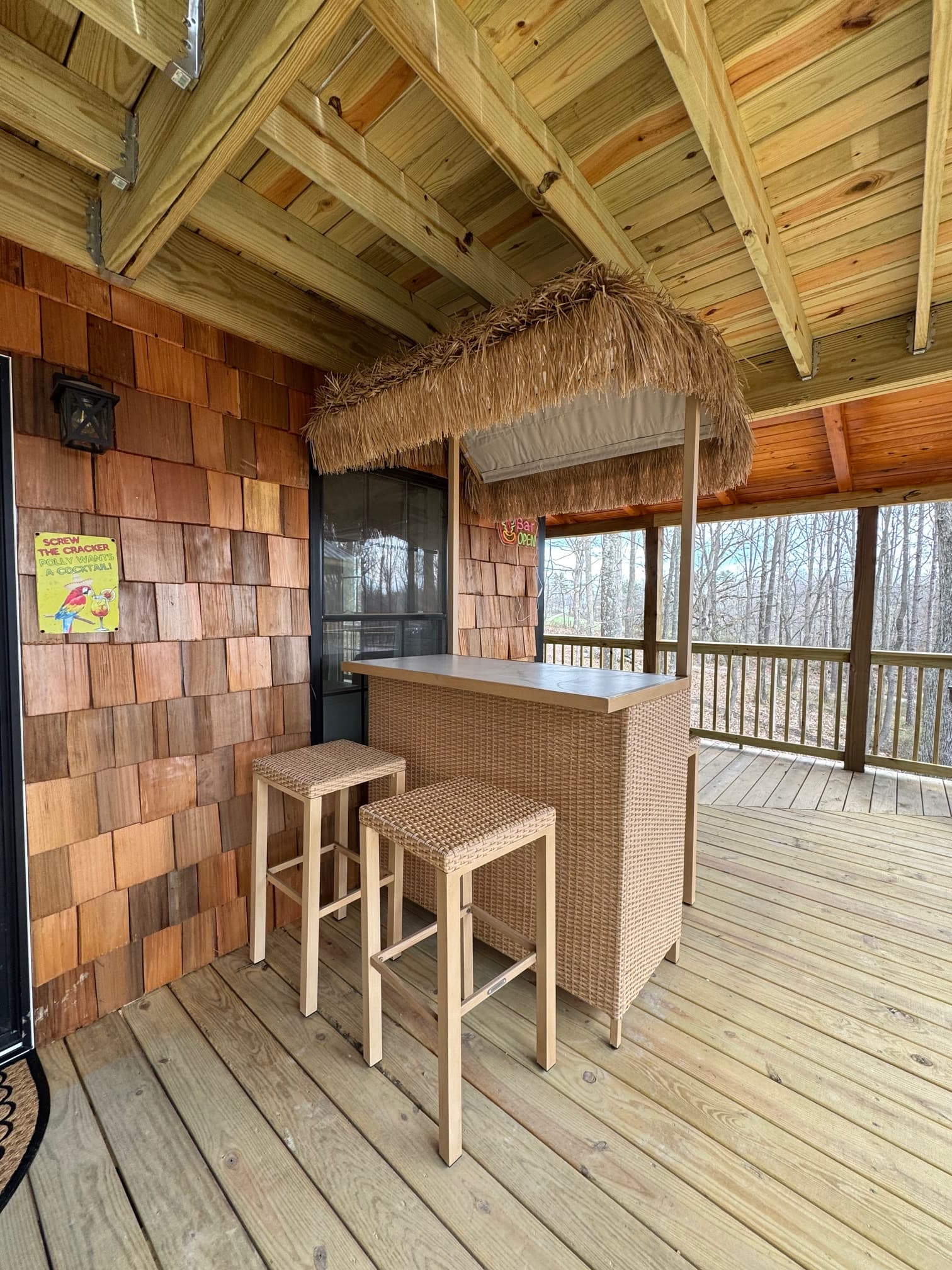 Tropical-style bar with straw awning and wooden seating on a deck.